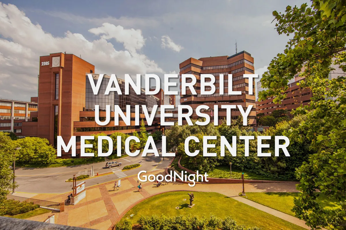 This image features the exterior of Vanderbilt University Medical Center, surrounded by landscaped walkways and lush greenery. The building's modern architecture stands out, complemented by a comforting and hopeful atmosphere.